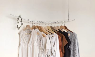 white brown and grey shirts hanging on a rack against a white wall